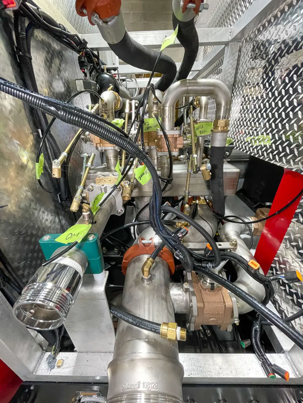 Exterior view of small fire truck showing cab, body compartments, and wheel/tire area.